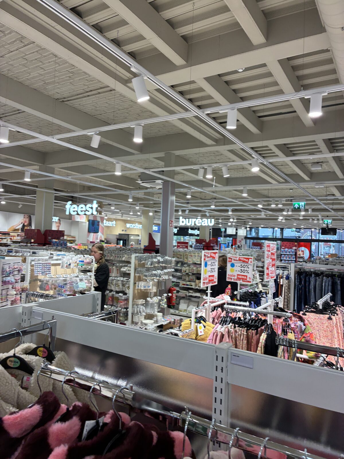 Sieradendisplays in de winkel naast een pilaar met beveiligingscamera en monitor met camerabeeld.